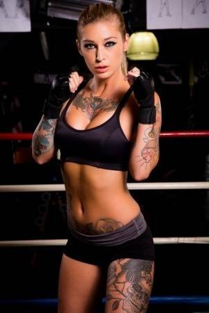 Tattooed MILF pornstar Kleio Valentien in shorts showing big tits in gym on fanspics.net