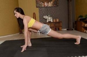 Cute brunette babe Aruna Aghora doing yoga in shorts and bare feet on fanspics.net