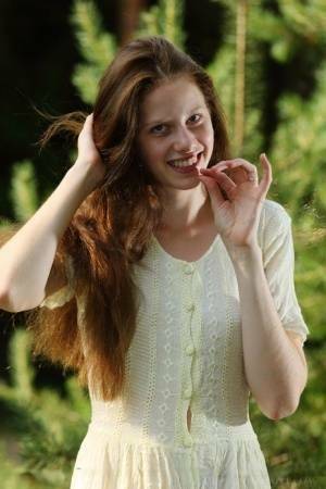Pale girl with long red hair Nicole K gets totally naked amid saplings on fanspics.net