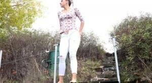 Mature Bianca pulls down her white pants to take a steaming pee outside on fanspics.net