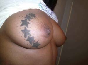 Ebony amateur takes self shots of her big tattooed boobs and bald vagina on fanspics.net