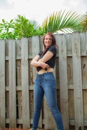 Hot redhead Andy Adams loses her t-shirt & jeans in the yard to pose naked on fanspics.net