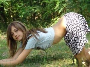 Shapely young teen in tiny t-shirt and short skirt posing outdoors on fanspics.net