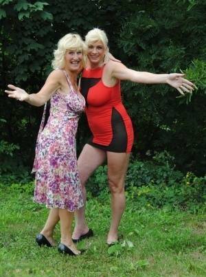 Mature lesbian Dimonty and GF cover their naked bodies in see thru raincoats on fanspics.net