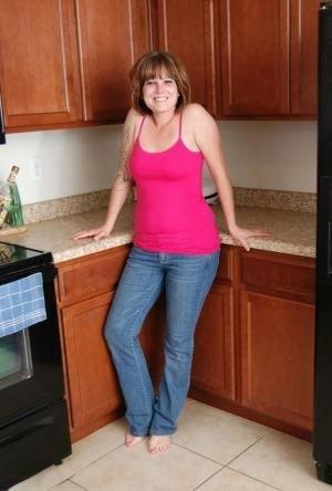 Redhead amateur Misty B gets completely naked in her kitchen on fanspics.net