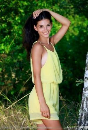 Nice teen Aleksandrina exposes her tan lined body by a hardwood tree on fanspics.net