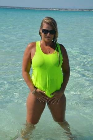 Middle-aged blonde Sweet Susi exposes her ass and pussy while in the ocean on fanspics.net