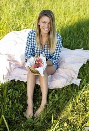 Nice teen Paulina gets completely naked on a blanket in a field on fanspics.net