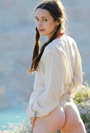 Teen model Ilona B poses nude in pigtails high above ocean waters on fanspics.net