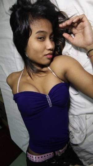 Filipina teen Porn shows her trimmed muff up close after getting nude on a bed on fanspics.net