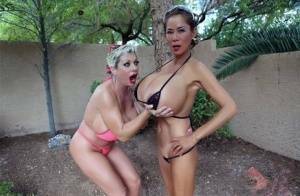 Big titted older women Claudia Marie and Minka kiss outdoors in skimpy bikinis on fanspics.net