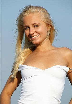 Blonde teen gets totally naked to for a solo shoot up on a hilltop on fanspics.net