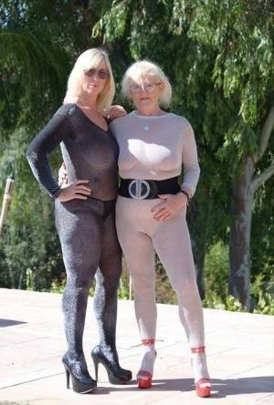 Mature blonde Melody and her lesbian lover bare their boobs on a building site on fanspics.net