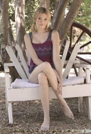 Teen first timer Lena Anderson vaunts her lithe body under a tree outside on fanspics.net