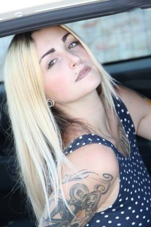 Tattooed girl Medusa Blonde shows her bare feet and ass while in a car on fanspics.net