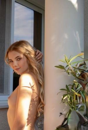Young blonde Chanel Fenn shows her sexy ass while getting naked in a garden on fanspics.net