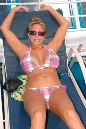 Hugely busty Amber Lynn Bach doffs her bikini to spread her legs wide nude on fanspics.net