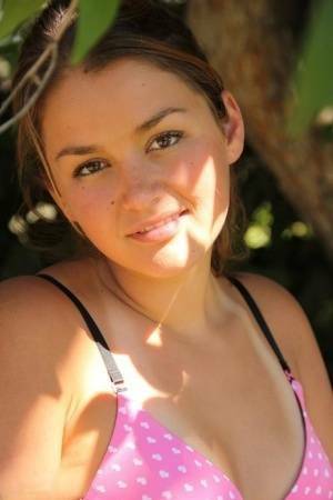 Petite amateur Allie Haze shows her tan lined body in the shade of a tree on fanspics.net